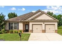 Charming single-story home with a well-manicured lawn and attached two-car garage at 697 Emporia Loop, Mcdonough, GA 30253