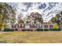 Charming one-story brick home featuring classic shutters, a well-maintained lawn, and inviting curb appeal at 7111 Indian Creek Sw Cir, Covington, GA 30014