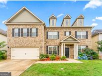 Charming two-story home with a brick facade, manicured lawn, and a two-car garage at 412 Culloden Moor, Mcdongough, GA 30253