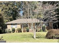Charming single-story brick home with a well-maintained front yard and mature trees at 984 Morrow Rd, Morrow, GA 30260