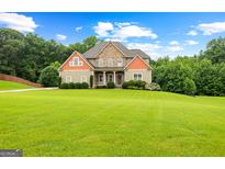 Charming two-story home with stone accents, a welcoming front porch, and a lush green lawn at 360 Grandmas Ln, Fayetteville, GA 30215