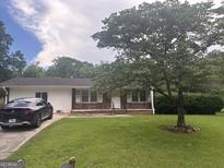Charming single-story home with a well-maintained front yard and mature tree at 3885 Morning Creek Dr, South Fulton, GA 30349