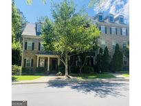 Traditional brick exterior of a multi-story home featuring a covered entryway and manicured landscaping at 241 Perimeter Walk, Atlanta, GA 30338