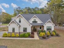 Stunning two-story home with craftsman-style details, lush landscaping and inviting entrance at 319 S Mount Carmel Rd, Mcdonough, GA 30253