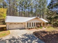 Charming single-story home with a well-manicured front yard, attached garage, and a beautiful metal roof at 1190 N Ola Rd, Mcdonough, GA 30252