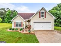 Charming one-story home featuring an attached garage, well-manicured lawn, and complementary landscaping at 161 Mills Dr, Covington, GA 30016