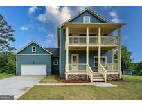 New construction features a double porch, well-manicured lawn and an attached garage at 1993 Reynolds Sw Dr, Atlanta, GA 30315