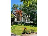 Charming two-story home featuring a covered porch and manicured lawn, nestled among lush trees at 1168 Mclynn Ne Ave, Atlanta, GA 30306
