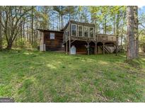 Exterior view of a rustic home featuring a wood exterior and a spacious yard at 655 Sunset Dr, Locust Grove, GA 30248
