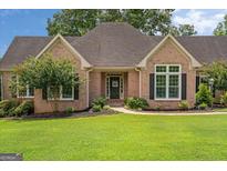 Charming brick home with meticulously maintained front lawn and mature landscaping at 10 Wigwam Cir, Whitesburg, GA 30185