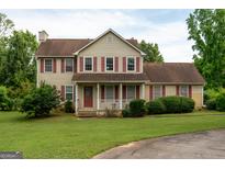 Traditional two-story home with red shutters, red front door, and well-maintained lawn at 2763 Hunters Ct, Hampton, GA 30228