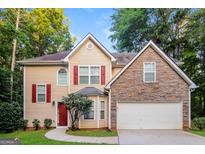 Charming two-story home with stone accents, red shutters, and a well-manicured lawn at 8330 N Sterling Lakes Dr, Covington, GA 30014