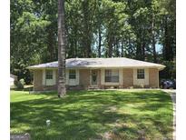 Charming brick home with a well-manicured lawn and mature trees at 10178 Top Tree Ct, Jonesboro, GA 30238