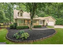 Charming two-story home featuring a cozy front porch, manicured landscaping, and an attached two car garage at 4080 Derby Dr, Cumming, GA 30040