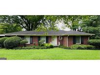 Charming brick home featuring black shutters and a well-manicured lawn and landscape at 506 Fayetteville Rd, Jonesboro, GA 30236