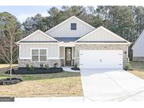 Charming one-story home boasts a manicured lawn, brick accents, and a two-car garage at 3363 Arabian Farm Ln, Dacula, GA 30019