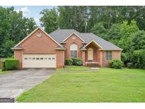 Charming brick home with well-manicured lawn and attached two-car garage at 1214 Lambeth Se Way, Conyers, GA 30013