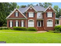 Beautiful brick home featuring manicured lawn and classic architectural details, including black shutters and a symmetrical facade at 1014 Overlook Dr, Villa Rica, GA 30180