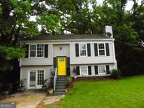 Charming home with a bright yellow front door, black shutters, and a well-maintained lawn at 4651 Garden Hills Dr, Stone Mountain, GA 30083