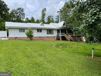 Charming single-story home featuring a white metal roof and lush green lawn at 1470 Dunn Rd, Cumming, GA 30040