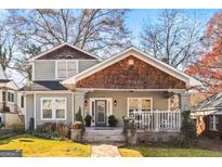 Charming two-story home featuring a quaint front porch, unique cedar shake details, and a landscaped front yard at 1450 Elizabeth Ln, East Point, GA 30344