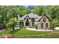 Stunning two-story home featuring stone accents, a well-manicured lawn, and a charming water fountain at 2878 Heather Row Sw Rdg, Lilburn, GA 30047