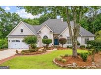 Charming single Gathering home with a well-manicured lawn, brick path, and three car garage at 134 Mellington Ln, Peachtree City, GA 30269