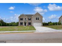 Gorgeous two-story brick home with an attached two-car garage and well-manicured lawn at 120 Felicity Pike, Locust Grove, GA 30248