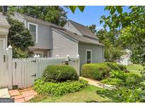 Charming home exterior with a white picket fence and well-maintained landscaping creating a welcoming curb appeal at 2694 Greentree Se Dr, Marietta, GA 30067