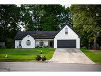 Charming one-story home features a black roof, two-car garage, and a well-manicured lawn at 1612 Cagle Ct, Lawrenceville, GA 30045