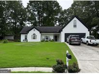 Charming white home with a manicured front yard, a covered entryway, and an attached two-car garage at 1612 Cagle Ct, Lawrenceville, GA 30045