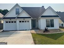 Charming single-story home with a two-car garage, landscaped front yard, and inviting gray front door at 240 Turnbridge Cir, Peachtree City, GA 30269