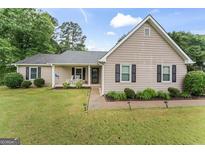 Charming home with well-manicured lawn, rocking chairs on the porch, and swing at 200 Pine Tree Ln, Mcdonough, GA 30252