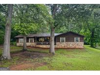 Charming single-story home with stone accents and a welcoming front porch, nestled among mature trees in a quiet setting at 69 Trace Ct, Stockbridge, GA 30281