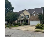 Charming two-story home with a brick facade and attached two-car garage at 12402 Muir Field Ct, Fayetteville, GA 30215