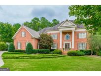 Stately brick home with manicured lawn, grand entrance, and classic architectural details at 6205 Arnall Nw Ct, Acworth, GA 30101