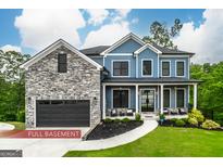 Two-story blue home with stone accents, manicured lawn, and inviting front porch at 5490 Bent Grass Way, Douglasville, GA 30135