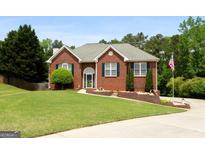 Charming brick home featuring a lush lawn, manicured landscaping, and inviting curb appeal at 1112 Haver Ct, Mcdonough, GA 30252