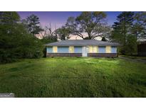 Charming single-story home with a well-maintained lawn and inviting curb appeal at twilight at 758 King Rd, Jonesboro, GA 30236
