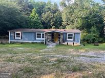 Charming single-story home with a spacious front yard and mature trees at 7138 Rockland Rd, Lithonia, GA 30038