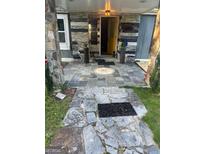 Charming front porch with stone pavers and rustic columns at 7138 Rockland Rd, Lithonia, GA 30038