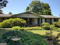 Charming brick ranch-style home featuring a symmetrical design and a well-manicured front yard with mature landscaping at 1753 Brenda Dr, Jonesboro, GA 30236
