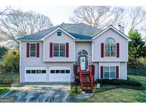 Charming home featuring red shutters, a well-manicured lawn, and a two-car garage at 402 Stonebrooke Dr, Auburn, GA 30011