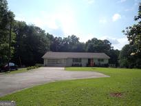 Charming one-story home featuring an attached garage, a large front yard and a paved driveway at 3025 Ebenezer Rd., Se Rd, Conyers, GA 30094