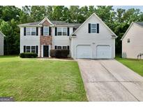 Charming two-story home with a well-manicured lawn, attached two-car garage, and traditional design elements at 3205 Anneewakee Falls Pkwy, Douglasville, GA 30135