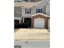 Two-story townhome with a brick garage and covered front porch, offering a convenient parking solution at 106 Ne Ellis Dr # 106, Conyers, GA 30012