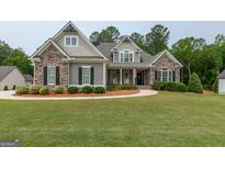 Charming home featuring stone accents, manicured landscaping, and a welcoming walkway at 319 Beaconsfield Dr, Sharpsburg, GA 30277