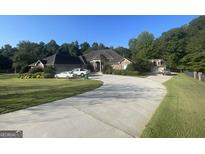 Attractive single-story brick home with an attached garage, long driveway, and well-manicured front yard at 624 Kristen Ct, Mcdonough, GA 30252