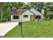 Charming white bungalow with a yellow door and a neatly manicured lawn at 203 First Leaf, Peachtree City, GA 30269
