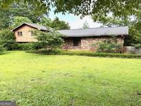 Charming home featuring a brick facade and lush green lawn at 8832 Twin Oaks Dr, Jonesboro, GA 30236